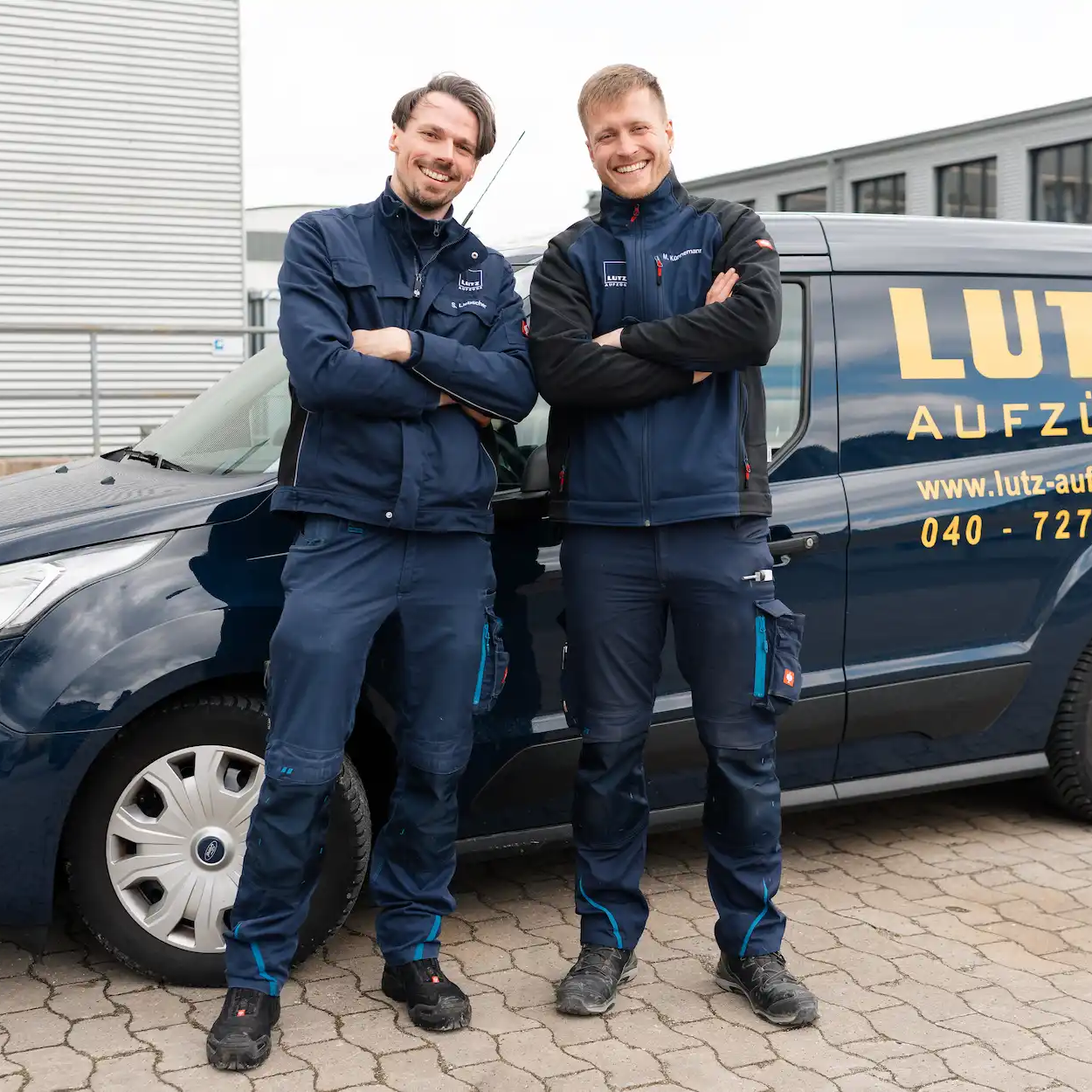 Two service technicians stand in front of LUTZ car